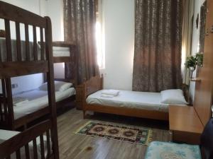 a room with two bunk beds and a staircase at Rose Hostel in Tirana