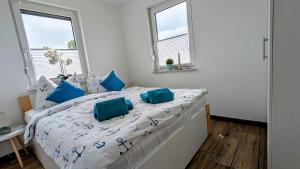 ルブミンにあるFerienwohnung Strandliebeのベッドルーム1室(青い枕のベッド1台付)