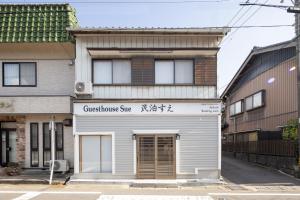 a building with a sign for a store at ゲストハウスすえ in Mashizume