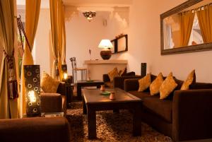 a living room with couches and a table at Riad Dar Foundouk and Spa in Marrakesh