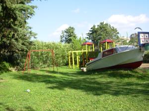 łódź siedząca na dziedzińcu z placem zabaw w obiekcie Residence L'Ulivo w mieście Budoni