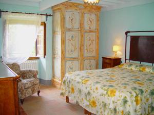 sypialnia z łóżkiem, krzesłem i telewizorem w obiekcie Agriturismo Il Trebbio w mieście Sansepolcro