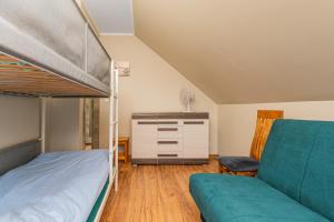 a bedroom with a bunk bed and a couch at Willa Słoneczna in Sztutowo