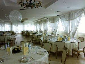 un comedor con mesas y sillas blancas en Hotel Villa Alessandra, en Alanno