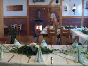 ein Esszimmer mit Tischen, Stühlen und einem Kamin in der Unterkunft Landhotel Gutsherrn-Klause in Dankerode