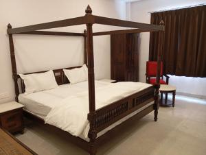a bedroom with a canopy bed and a chair at Hotel Har Niwas udaipur city of lakes in Udaipur