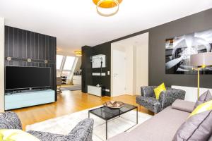 a living room with a couch and a tv at Abieshomes Serviced Apartments - Messe Prater in Vienna