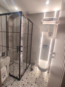 a bathroom with a shower and a toilet with lights at Mara Oldcity Hotel in Istanbul