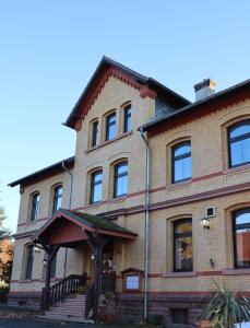 a large brick building with a porch on a street at Hotel-Restaurant zur Post in Wabern