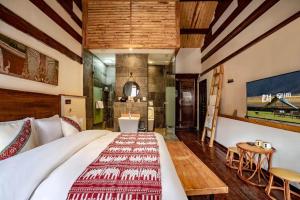 Shangrila Agedtree Hotel في شانغريلا: غرفة نوم بها سرير كبير وحمام