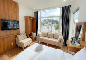 una camera da letto con un letto, un divano e una finestra di Thanh Thanh Station View a Da Lat Altre 21 foto