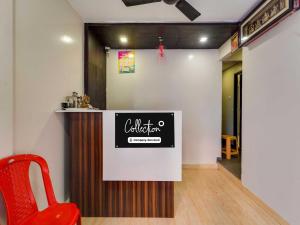 a bar in a room with a red chair at Collection O MA Chidambaram Stadium Sarvanas Park in Chennai
