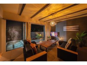 - un salon avec des canapés, une table et une fenêtre dans l'établissement YUHUROTEN TOKI NO MANIMANI - Vacation STAY 87025, à Yufu