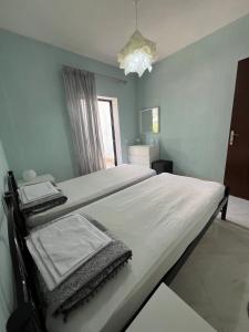 a bedroom with two beds and a window at Ground floor Apartment with Garden in Polykhrono