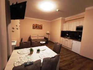 a living room with a dining table and a kitchen at Aquakaros Apartman Zalakaros in Zalakaros