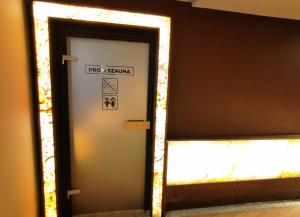 a mirror reflection of a door with a sign on it at Aquakaros Apartman Zalakaros in Zalakaros