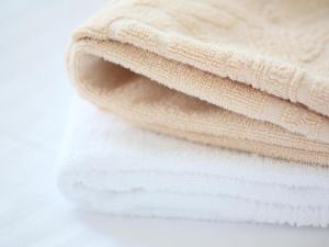 a stack of white towels on a white table at APA Hotel Owari Ichinomiya Eki-mae in Ichinomiya +68 photos