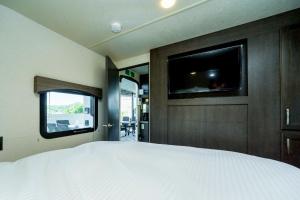 上天草市にあるumisolaieのベッドと薄型テレビのある寝室