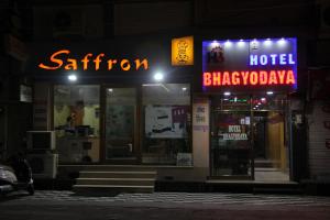 a hotel with a neon sign at night at Hotel Bhagyodaya Residency Bhilwara in Hāmīrgarh