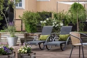 two chairs and a table on a deck with flowers at Clarion Collection Hotel Cardinal in Växjö