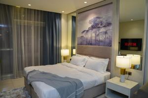 Un dormitorio con una cama grande y dos lámparas. en Studio with Burj Khalifa view, en Dubái