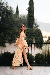 a woman in a dress walking next to a fence at Luxury Villa Silente in Mjull-Bethore