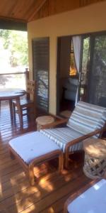 a porch with benches and a table on a deck at The Sissing Sanctuary in Mpemba