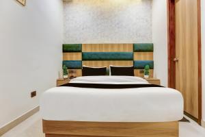a bedroom with a large bed with a wooden headboard at Hotel O S.C HEIGHTS in Amritsar