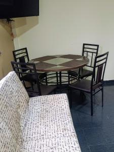 a wooden table and chairs with a table and a couch at Pequeño departamento todo incluido in Mérida