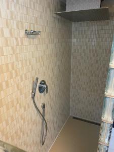 ブラウボイレンにある3 Zimmer Ferienwohnung Blaubeurenのタイル張りのバスルーム(シャワー、ホース付)