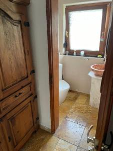 ブラウボイレンにある3 Zimmer Ferienwohnung Blaubeurenのバスルーム(トイレ付)、木製のドアが備わります。 +2枚の写真