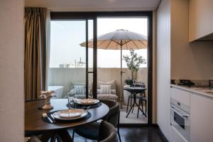 a kitchen and dining room with a table with an umbrella at Los 36 by GRUPO CCOMMO in Murcia