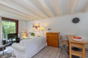 a living room with a white couch and a table at Vakantiewoning bij het Veerse Meer in Wolphaartsdijk