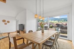 a dining room with a wooden table and chairs at Sunset Club - Nesselwang Chalets Nr 1 in Nesselwang
