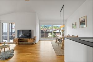 a living room with a television and a table with chairs at Sunset Club - Nesselwang Chalets Nr 1 in Nesselwang