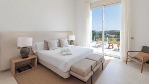a white bedroom with a bed and a large window at Villa Selena Antequera by Ruralidays in Antequera +55 photos