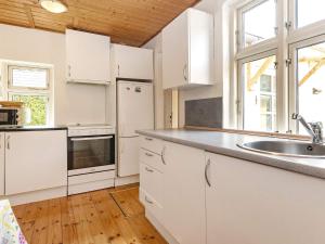 a kitchen with white cabinets and a sink at 6 person holiday home in Marstal in Marstal