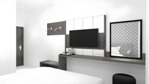 sala de estar con TV y cama en Smart Budget Hotel, en Stasiun Tawang