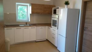 eine Küche mit weißen Schränken und einem weißen Kühlschrank in der Unterkunft Rosa Apartments in Ist