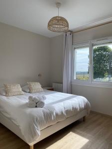 a bedroom with a white bed with towels on it at Cottage Stelie in Tocqueville-en-Caux