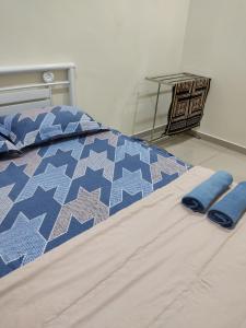 a bed with two blue pillows on top of it at Alieda Homestay 1 Near KLIA in Sepang