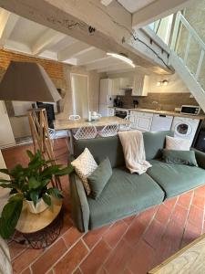 a living room with a couch and a kitchen at Gîte à la campagne in Secondigny