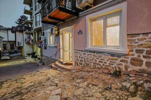 a house with a yellow door and a window at Hide Hub Guest Apart in Veliko Tŭrnovo