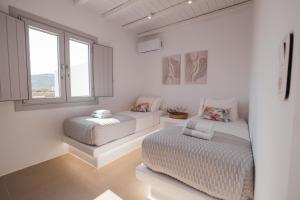 a white room with a couch and a bed at Xerolithos Natural Living in Naxos Chora +80 photos