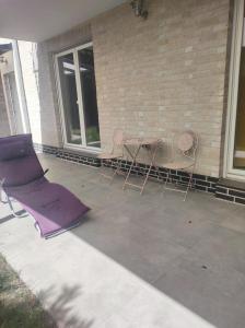 a patio with three chairs and a table and a building at Attraktive Neubauwohnung in Bremen