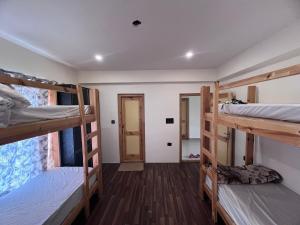 a room with three bunk beds and a hallway at De katong in Leh +10 photos