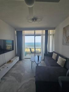 ein Wohnzimmer mit Couch und Blick aufs Meer in der Unterkunft Lazuli Beachfront Sea View Ap 34 in Larnaka