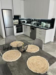 eine Küche mit einem Tisch, Stühlen und einer Theke in der Unterkunft Lazuli Beachfront Sea View Ap 34 in Larnaka