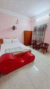 a bedroom with a bed with a red seat at Nhà Nghỉ Đức Anh 2 in Ðại Sơn