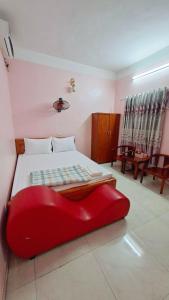 a bedroom with a large red couch sitting on a bed at Nhà Nghỉ Đức Anh 2 in Ðại Sơn +14 photos